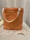 Back view of medium project tote in peach dot/bird