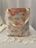 Rear view of medium project tote in peach graphic flower